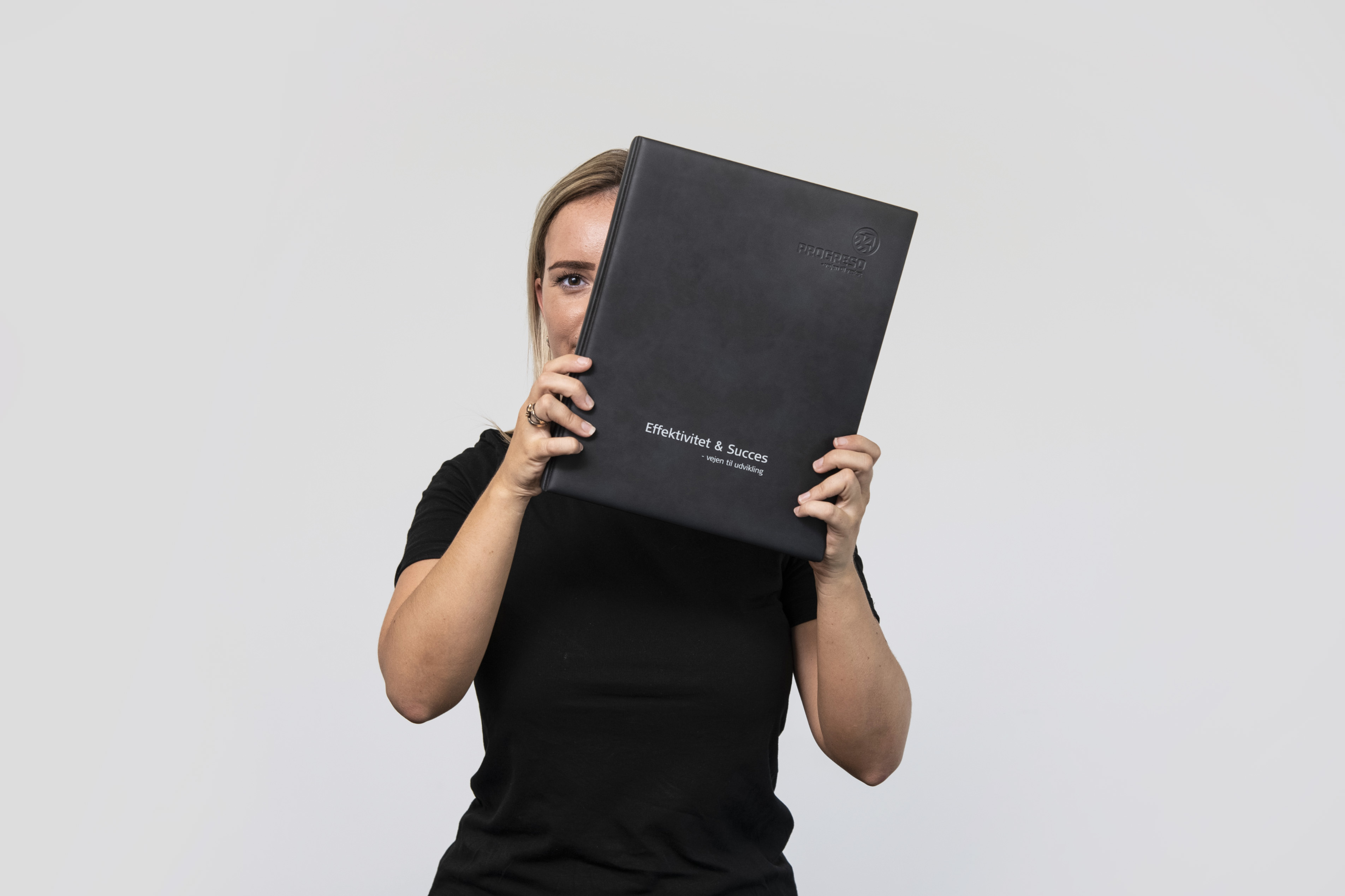 Pige der holder hæfte med teksten "Effektivitet og Succes"